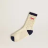 Calcetines acanalados de color crema con detalles en azul marino y logotipo rojo