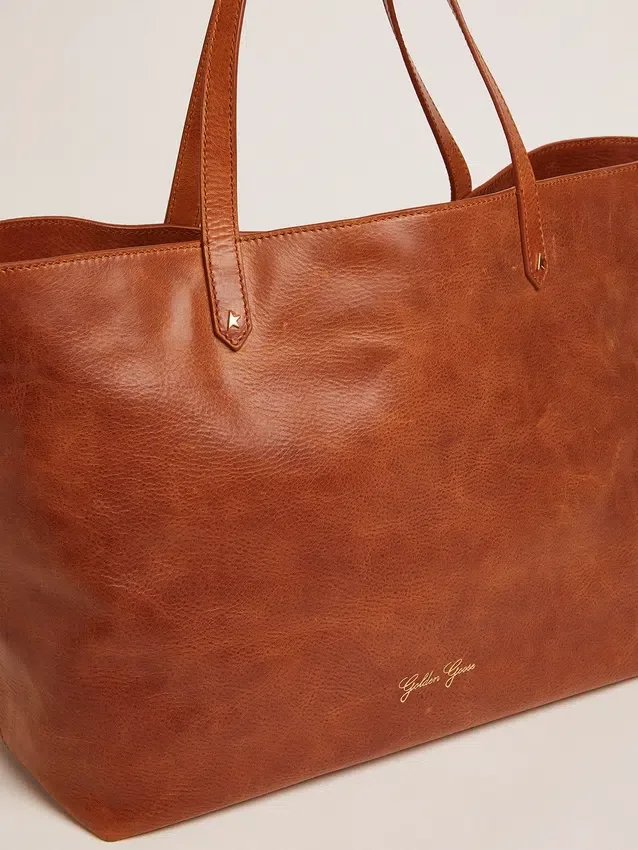 Bolso Pasadena en piel martillada brillante de color tostado con logotipo dorado en la parte delantera
