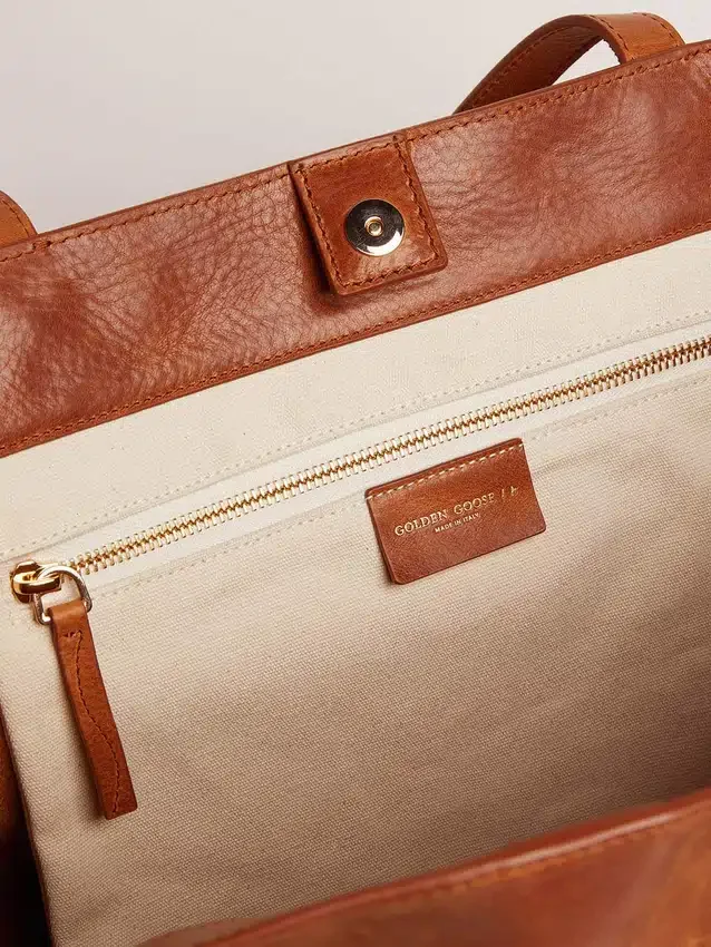 Bolso Pasadena en piel martillada brillante de color tostado con logotipo dorado en la parte delantera