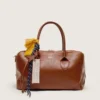 Bolso Vita mediano de piel marrón claro con dijes y detalles plateados