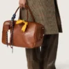 Bolso Vita mediano de piel marrón claro con dijes y detalles plateados