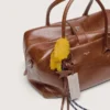 Bolso Vita mediano de piel marrón claro con dijes y detalles plateados
