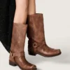 Botas moteras altas de mujer en piel marrón con correa y hebilla en color oro antiguo