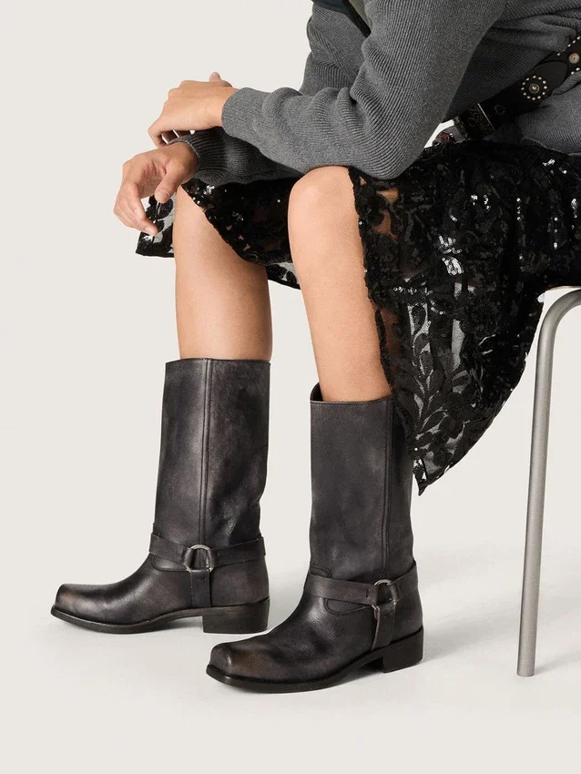 Botas moteras altas de mujer en piel negra con correa y hebilla plateada