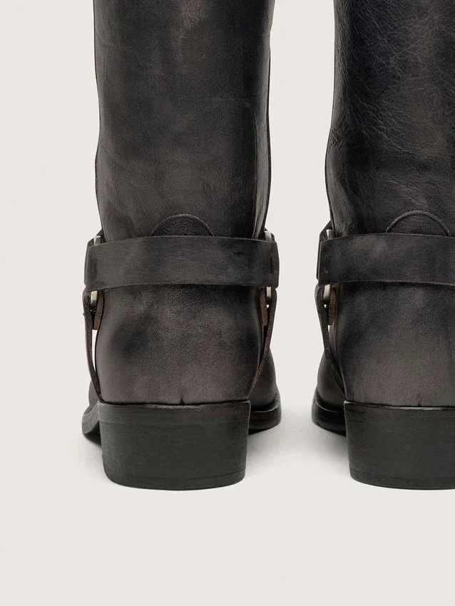 Botas moteras altas de mujer en piel negra con correa y hebilla plateada