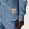 Camisas unisex «Journey» de cambray de algodón azul claro con bajo con flecos y parche bordado