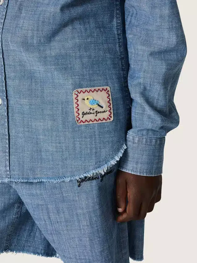 Camisas unisex «Journey» de cambray de algodón azul claro con bajo con flecos y parche bordado