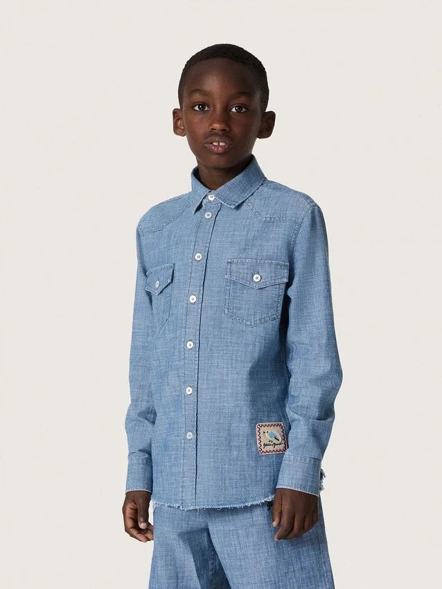 Camisas unisex «Journey» de cambray de algodón azul claro con bajo con flecos y parche bordado