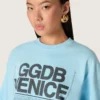 Camiseta corta de mujer en jersey de algodón azul claro con estampado gráfico