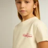 Camiseta de algodón para niñas en blanco desgastado con bordado rojo en el pecho