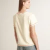 Camiseta de mujer color crema con detalles en rojo descolorido
