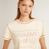 Camiseta de mujer color crema con detalles en rojo descolorido