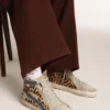 Chanclas Slide de mujer en piel de potro con estampado de leopardo y estrella de cuero plateada