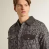 Chaqueta gris con diseño en espiga y detalles de cuero negro