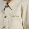 Chaqueta infantil de color beige con salpicaduras multicolores