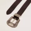 Cinturón de mujer de piel negra con hebilla decorada en color plateado