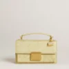 Colgante con forma de bolso de latón dorado con cristales