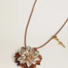 Colgante con forma de flor en piel color tostado y champán
