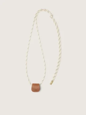 Estuche para gafas con una correa de senderismo de color crema y un clip de cuero de color tostado
