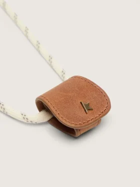 Estuche para gafas con una correa de senderismo de color crema y un clip de cuero de color tostado