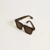 Gafas de sol Jamie de estilo cuadrado con montura negra y logotipo dorado