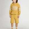 Pantalones cortos de jogging para niño en amarillo ocre con bordado