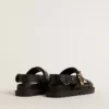 Sandalia Lucy para mujer en piel negra brillante con hebilla metálica dorada