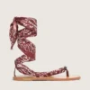 Sandalias planas de mujer con estampado de paisley burdeos y detalle de joya