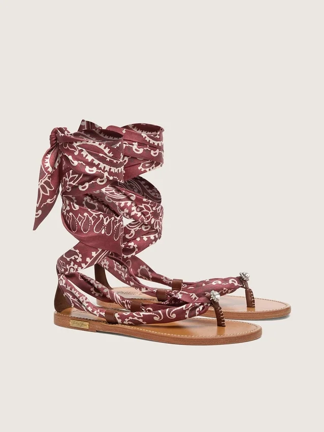 Sandalias planas de mujer con estampado de paisley burdeos y detalle de joya