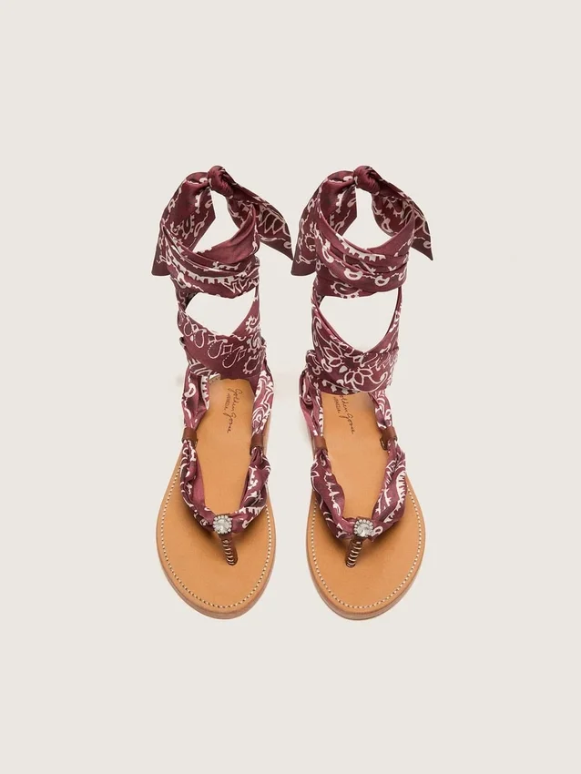 Sandalias planas de mujer con estampado de paisley burdeos y detalle de joya