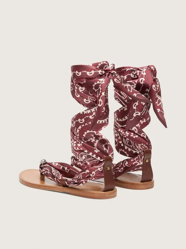 Sandalias planas de mujer con estampado de paisley burdeos y detalle de joya