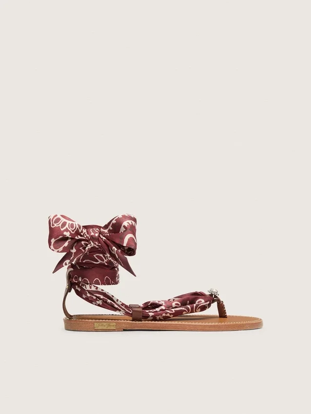 Sandalias planas de mujer con estampado de paisley burdeos y detalle de joya