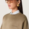 Sudadera unisex de algodón en tono verde militar con efecto desgastado y logotipo bordado