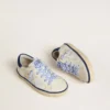 Super-Star Junior en piel blanca con lengüeta de ante azul en el talón