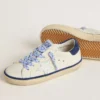 Super-Star Junior en piel blanca con lengüeta de ante azul en el talón