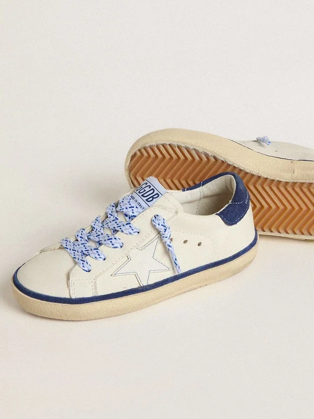 Super-Star Junior en piel blanca con lengüeta de ante azul en el talón