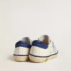 Super-Star Junior en piel blanca con lengüeta de ante azul en el talón